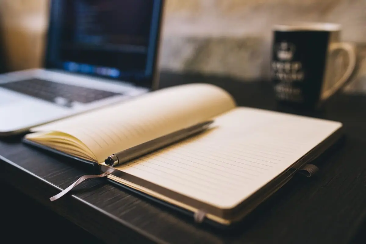 Notebook and laptop on an editor's desk